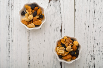 top view almonds and walnuts and cashew nuts and raisin and dry blueberries on two white dishes