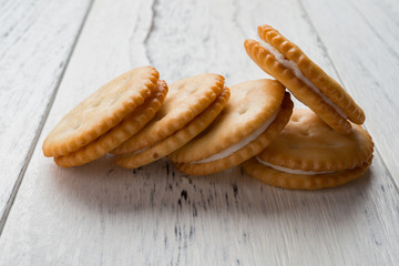sandwich biscuits with white cream filling on white wood background