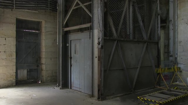A full shot of a metal door of a warehouse. Camera tilts up