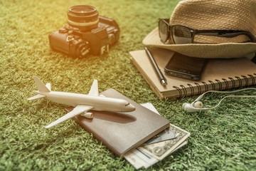 Tourist travel planning concept on grass with passport, airplane