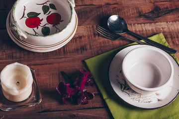 Table setting with ceramic plates, bowls, cutlery and orchid