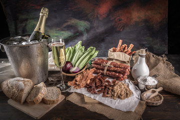 Champagne with delicious pieces of sliced ham, sausage, tomatoes, salad and vegetable - Meat platter with selection - Cutting sausage and cured meat