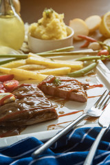 steak with vegetables, fries and barbecue sauce