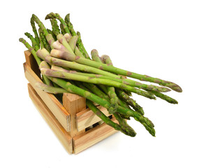 fresh green asparagus shoots in a wooden crate on a white background