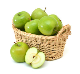 Green apples and halved in basket on a white background