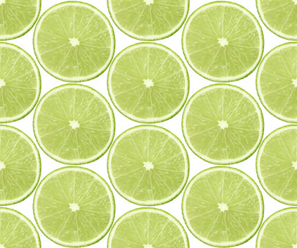 Seamless background with slices of lime fruits on white