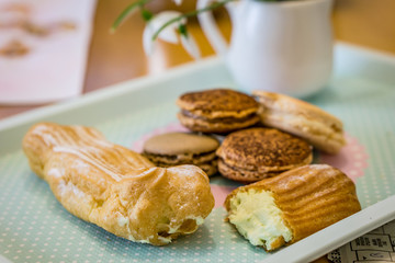 Close up of ecler and french macaroon with a taste of caramel and chocolate on a white background, shallow depth of focus. Concept Valentine day.