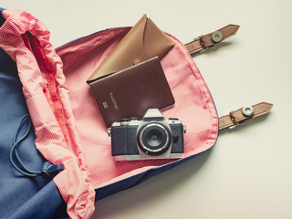 long holiday travel flat lay concept from blue backpack with retro camera , sunglasses with case and passport put on isolated white background
