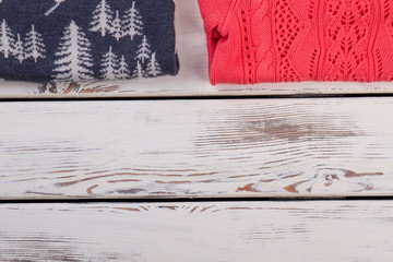 Handmade sweaters on wooden background