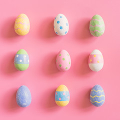 Colorful easter eggs on pink pastel color background with space.