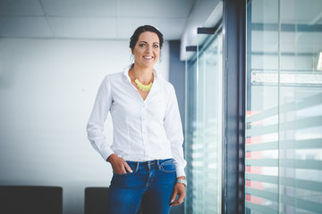 Fototapeta premium Beautiful brunette business woman standing in a boardroom