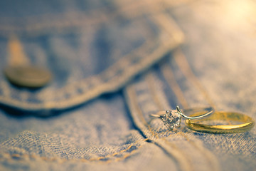Fake diamond ring and gold ring placed on Jean jecket. The concept of love or marriage. Copy space...