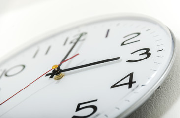 Clock on the white wall. Three o'clock.