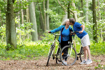 Fototapeta na wymiar Elderly couple kissing in the woods.