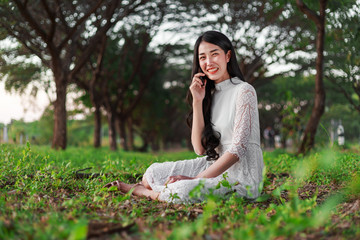 smiling woman talking on mobile phone in park