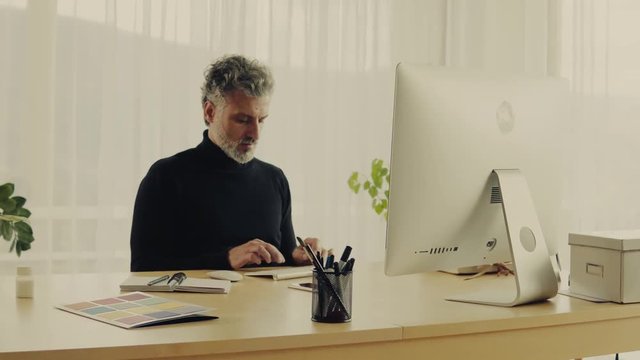 Mature man with computer working in home office.