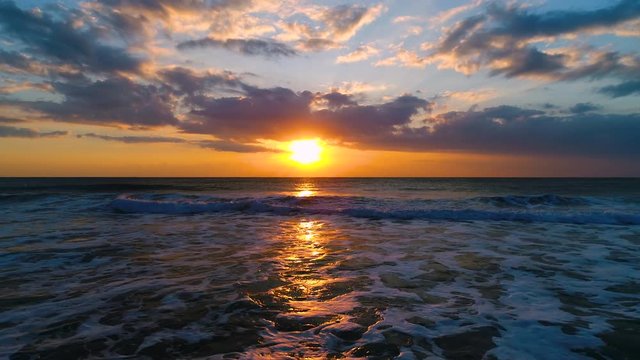 Aerial view of beautiful sunrise with dramatic cloudscape over the sea waves video