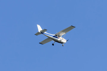 Fototapeta na wymiar Single engined light aircraft flying over a clear blue sky