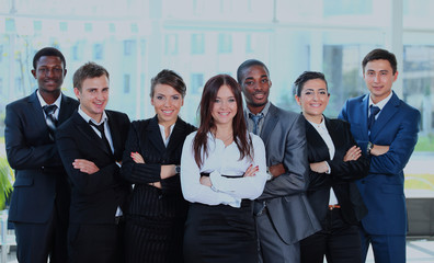 Happy young business woman with her team in background.