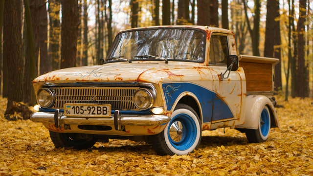 Retro cars truck creative solution with blue color artificial rust and wooden luggage in a fall forest