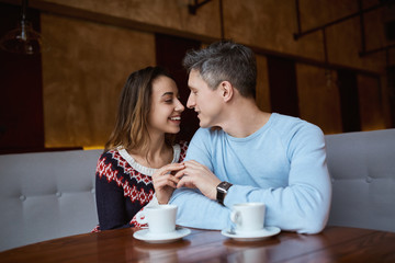 Man and woman drinking coffee in a cafe. Two people, man and woman in cafe communicate, laughing and enjoying the time spending with each other. Couple in love on a date. Love story and Valentines Day