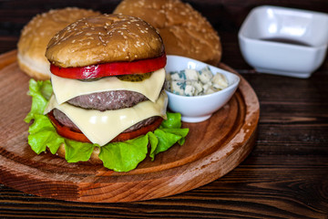 Homemade burger on wooden cutting board.