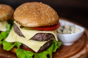 Homemade burger on wooden cutting board.