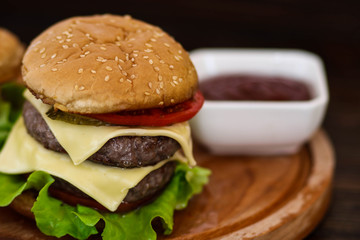 Homemade burger on wooden cutting board.
