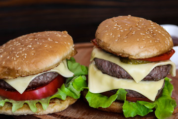 Homemade burger on wooden cutting board.
