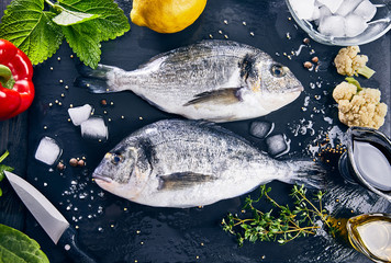 Fresh fish dorado top view. Spicy herb and vegetables. Spice