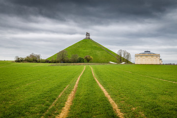 Famous Battle of Waterloo Lion's Mound memorial site with dark clouds, Belgium - obrazy, fototapety, plakaty