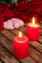 Fototapeta na wymiar Two burning candles with fresh roses