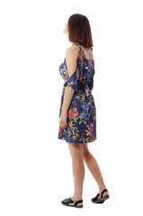 back view of standing young beautiful  woman.  girl  watching. Rear view people collection.  backside view of person.  The girl in a colorful dress looks to the side..