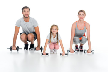 sportive parents and daughter with dumbbells isolated on white