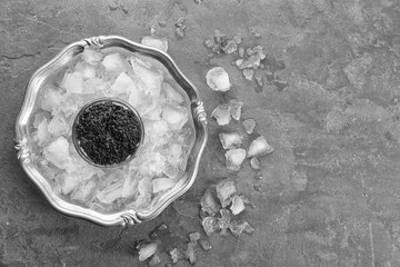 Black caviar served with ice on metal tray