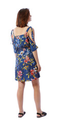 back view of standing young beautiful  woman.  girl  watching. Rear view people collection.  backside view of person.  The girl in a colorful dress looks upstairs.
