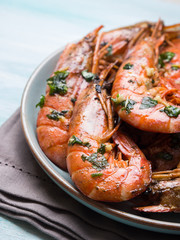 Grilled shrimps with parsley on pastel turqouise background. Shellfish dish