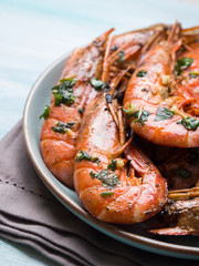 Grilled shrimps with parsley on pastel turqouise background. Shellfish dish