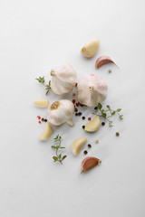 Fresh garlic and pepper grains on white background, top view