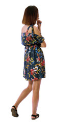 back view of standing young beautiful  woman.  girl  watching. Rear view people collection.  backside view of person.  The girl thinks in a colorful dress