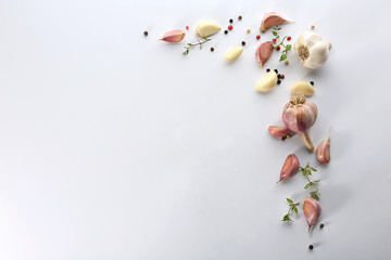 Fresh garlic and pepper grains on white background, top view