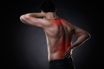 Back pain, man with backache on black background