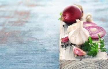 Fresh garlic and onion on color background, closeup
