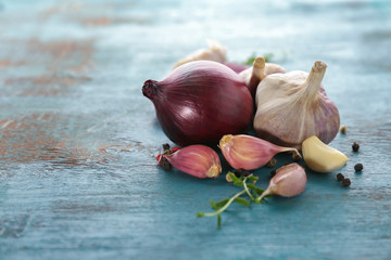 Fresh garlic and onion on color background, closeup