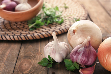 Fresh garlic and onion on wooden table, closeup