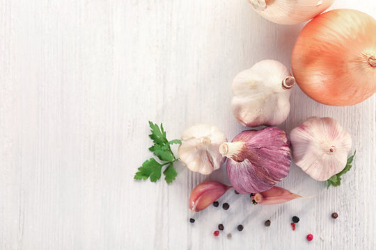 Fresh garlic, onion and pepper grains on light background, top view