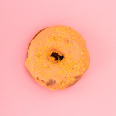 Donut with sprinkles isolated on pink background. Top view.