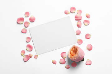 Rose petals, flower and empty card on light background