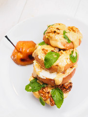 Sliced baked pear with peanut butter on white background