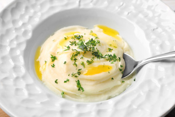 Mashed potatoes and spoon in plate, closeup